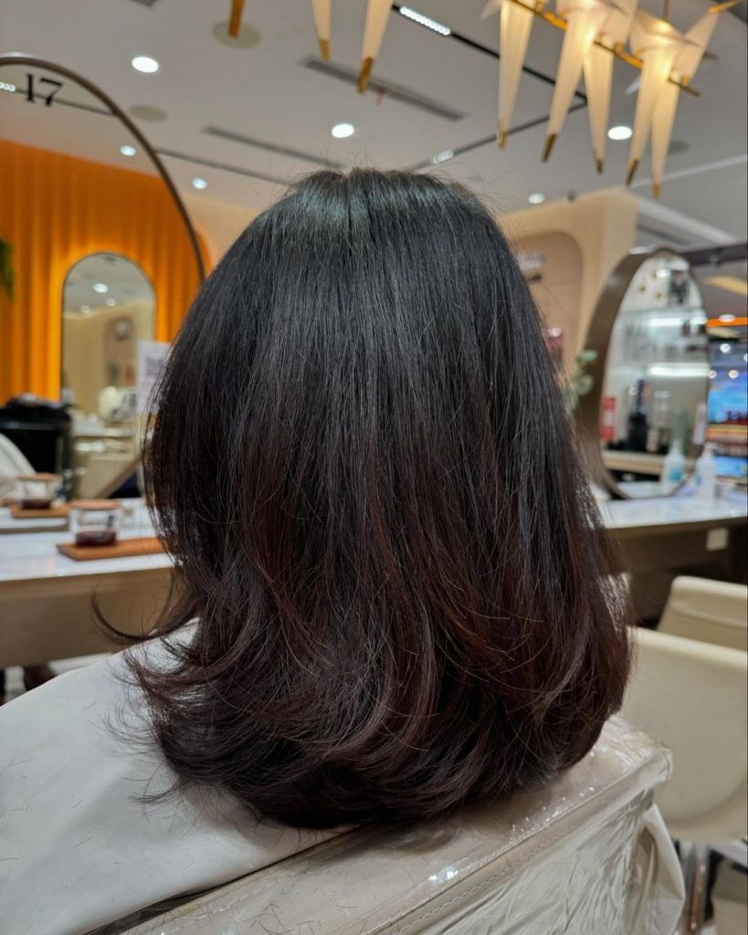 Shoulder-length haircut from the back with a softly curved perimeter and minimal layers